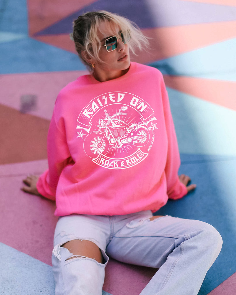 hot pink crew neck sweatshirt with white raised on rock and roll motorcycle motif