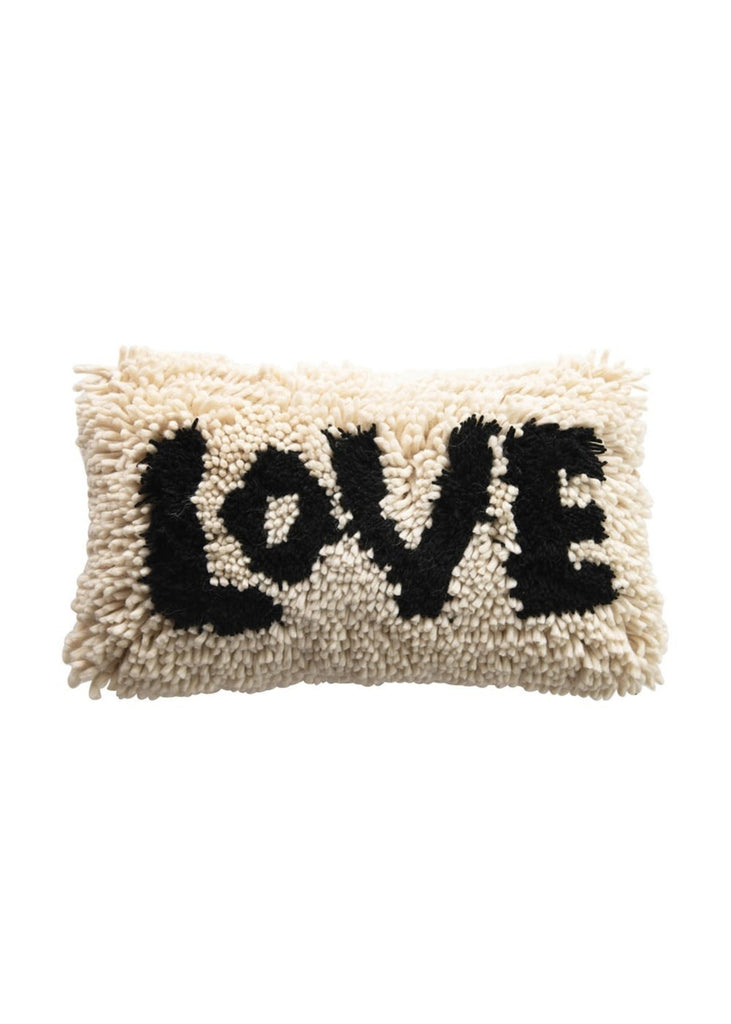 cozy long throw pillow with shaggy tassels and love in black text 